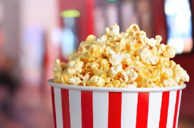 A bowl of popcorn is sitting on the table.