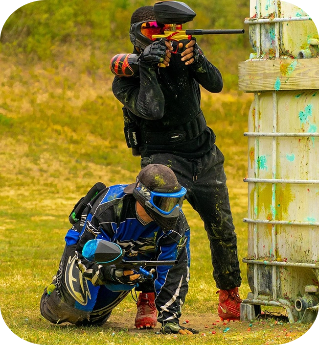 Two men in full gear are playing paintball.