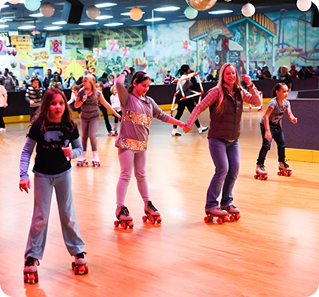 A group of young girls riding skateboards in an indoor rink.