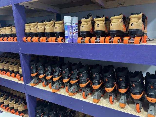 A row of roller blades sitting on top of shelves.